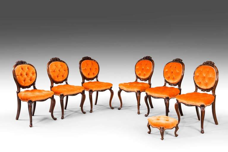An exceptionally fine set of six single chairs and a stool en suite, the chairs very finely carved with flowers and scrolls, the pronounced cabriole supports terminating in a 'French' scroll foot. Overall the finest quality.