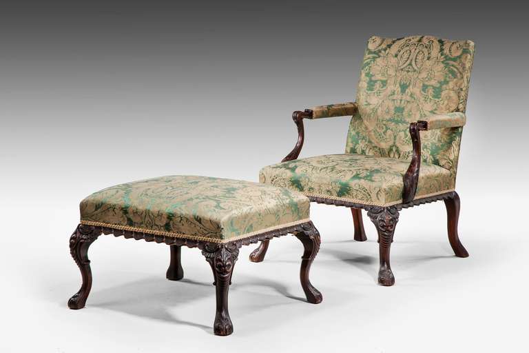 An unusual mahogany 19th century Gainsborough Armchair with an en suite stool, the rails with scalloped decoration, the supports and arms with finely carved leafs. 

A Gainsborough Armchair (also known as a Martha Washington chair in the United
