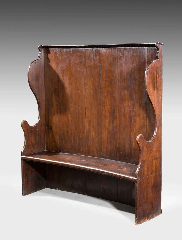George III period stained pine concave settle, shaped ends, in original condition.