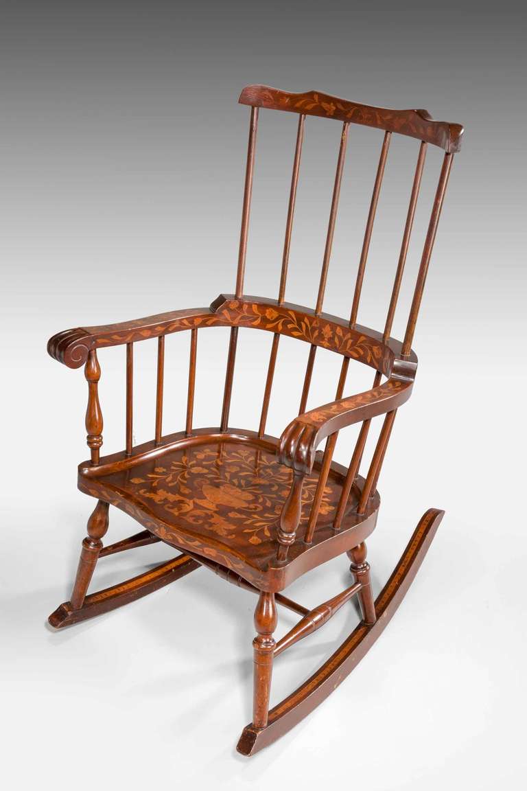 An unusual 19th century Dutch marquetry inlaid mahogany rocking chair in excellent condition.

Marquetry is the art and craft of applying pieces of veneer to a structure to form decorative patterns, designs or pictures. The technique may be