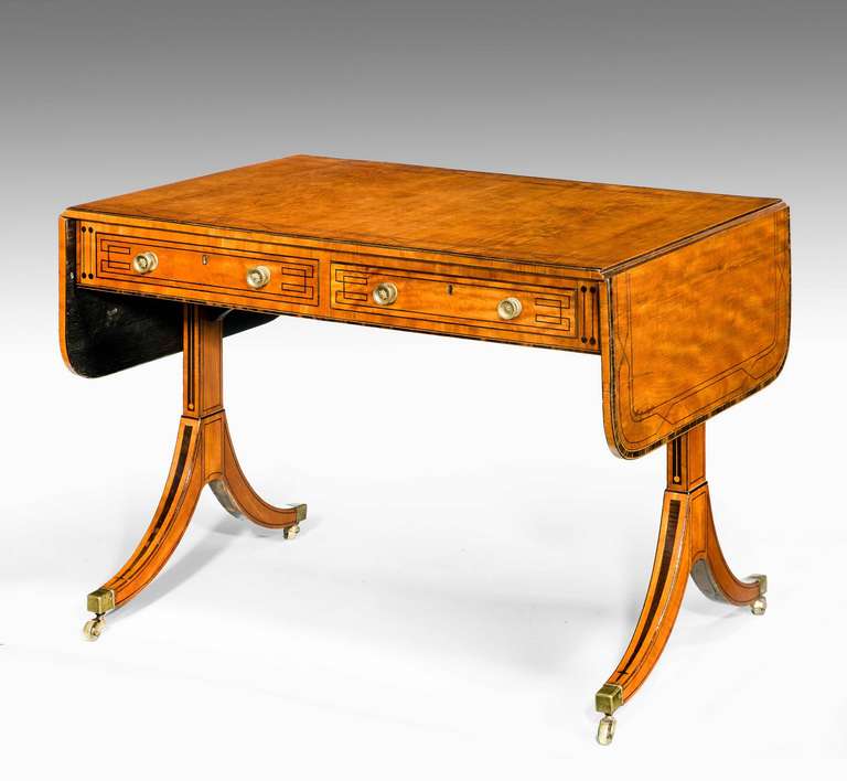 A very elegant George III period satinwood sofa table of well figured golden colored timber with ebony geometric line inlay on fine end supports with high swept feet.

RR.