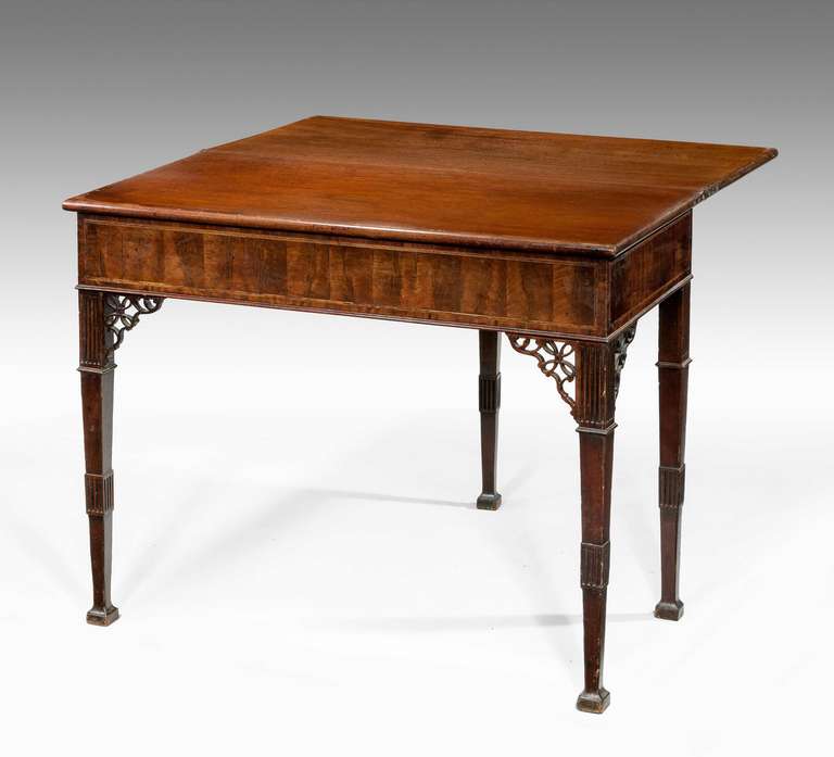 A Chippendale period mahogany tea table with particularly well chosen timbers to the front, elaborate pierced corner brackets on tapering square supports terminating in block toes.