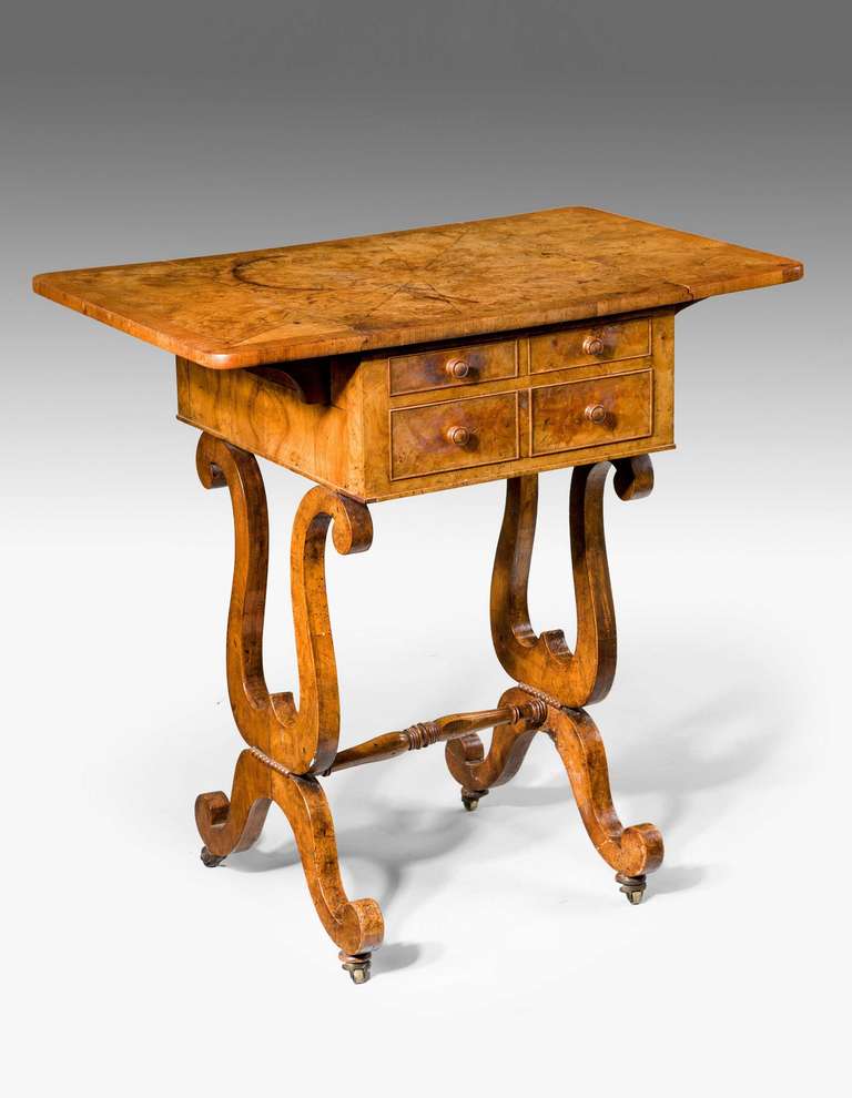 An exceptionally good Regency period amboyna work table of outstanding color and patina, the cross banded top over veneered lyre ends joined by a turned stretcher and scroll supports.
