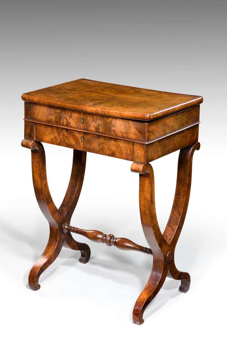 An elegant and beautifully figured mahogany work/dressing/writing table from the second quarter of the 19th century, the quartered top with a cushion mould, elegant veneered scrolling supports the whole of excellent quality.

