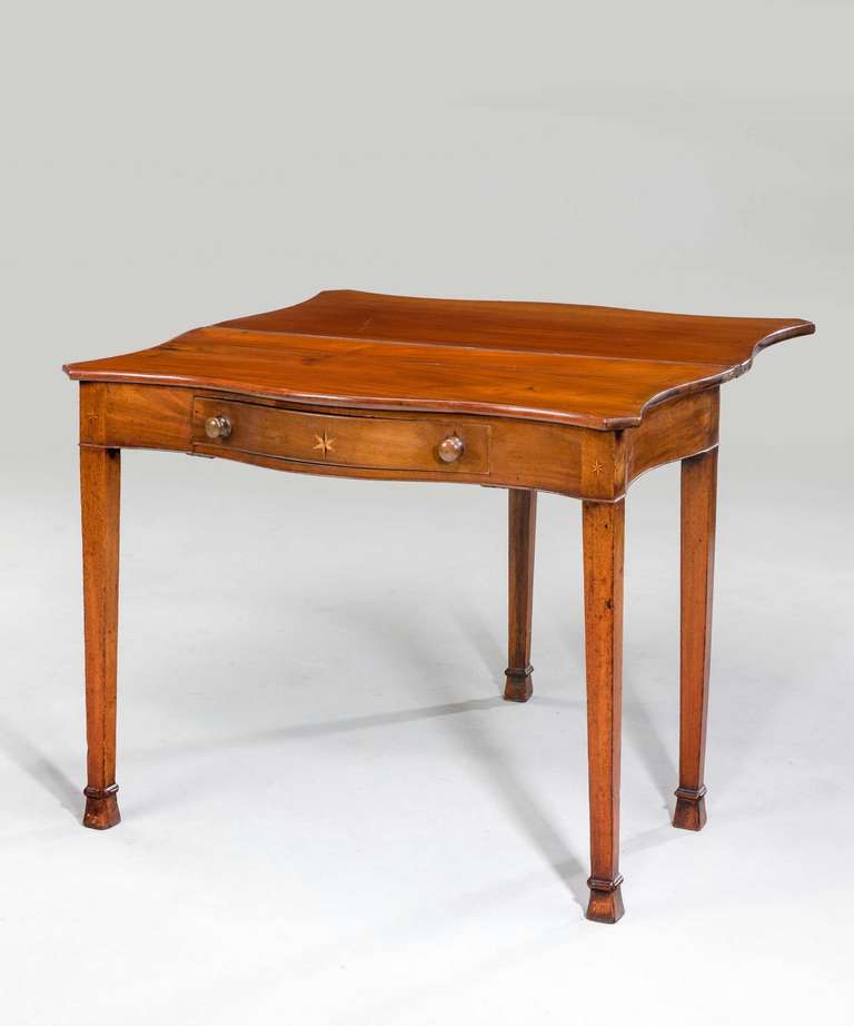 A Chippendale period serpentine mahogany Tea Table, the freeze incorporating a single drawer with boxwood and ebony inlay, the supports terminating in reverse spade feet.