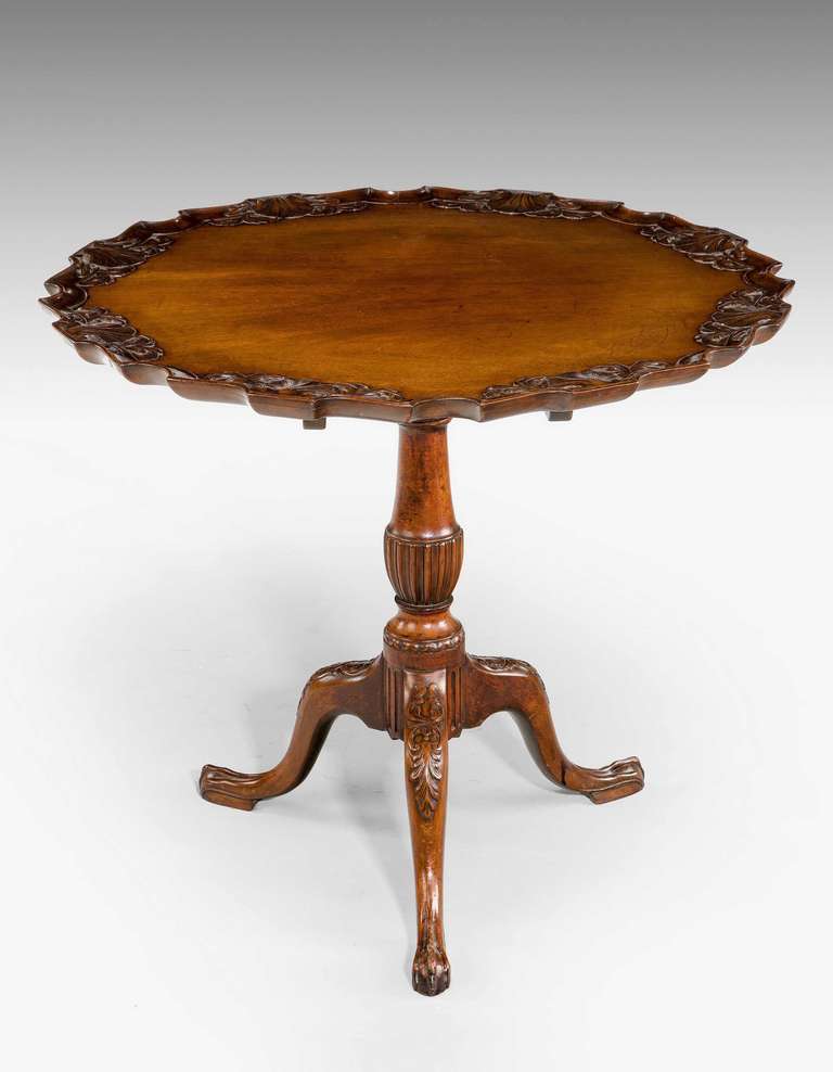 A very well carved mahogany tilt table with elaborate decoration to the edge of the top with conch shells and a centre support terminating in claw feet, of Chippendale style.

RR