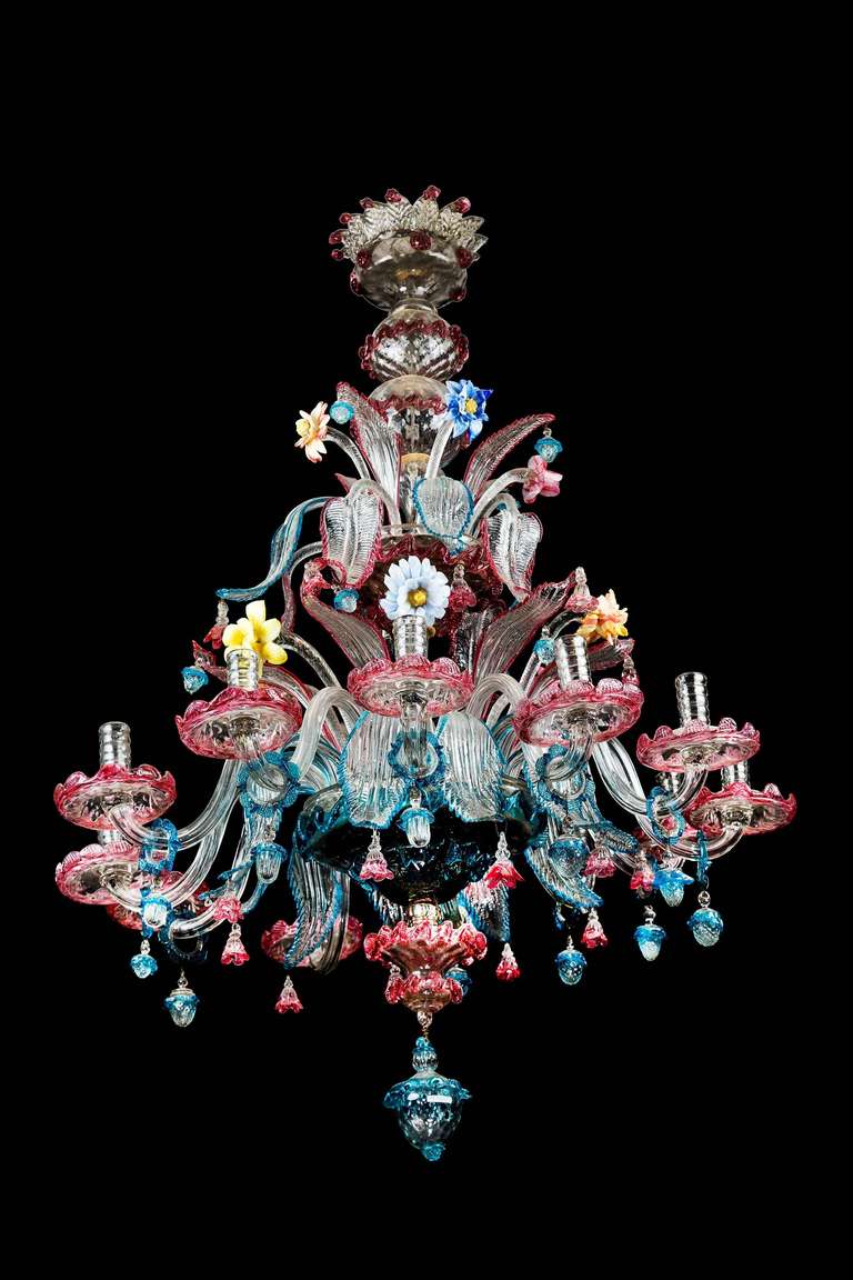Joli lustre vénitien de Murano, dont le corps est orné de fleurs et de feuillages bien modelés en verre moulé multicolore, les feuilles étant bordées de couleurs contrastantes et suspendues par des gouttes ovoïdes qui se chevauchent.