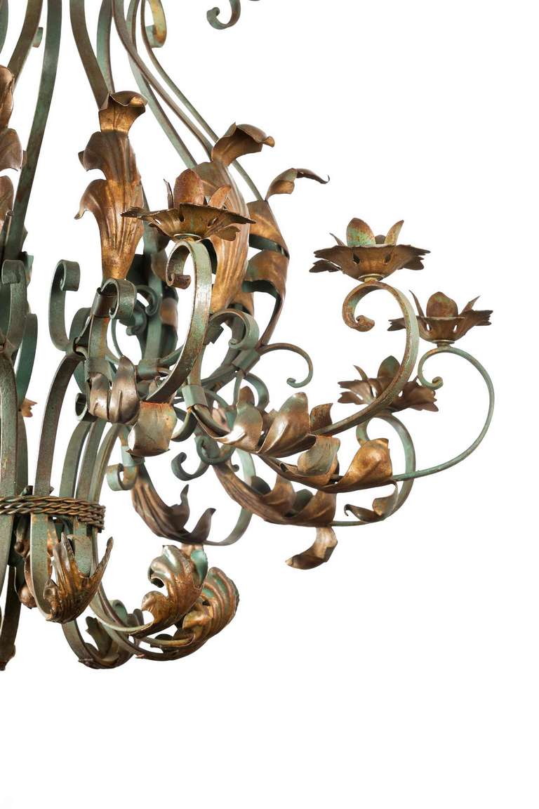 A large enamelled and softly gilded chandelier, the scrolling arms with applied leaf and floral decoration, late 19th century-early 20th century.