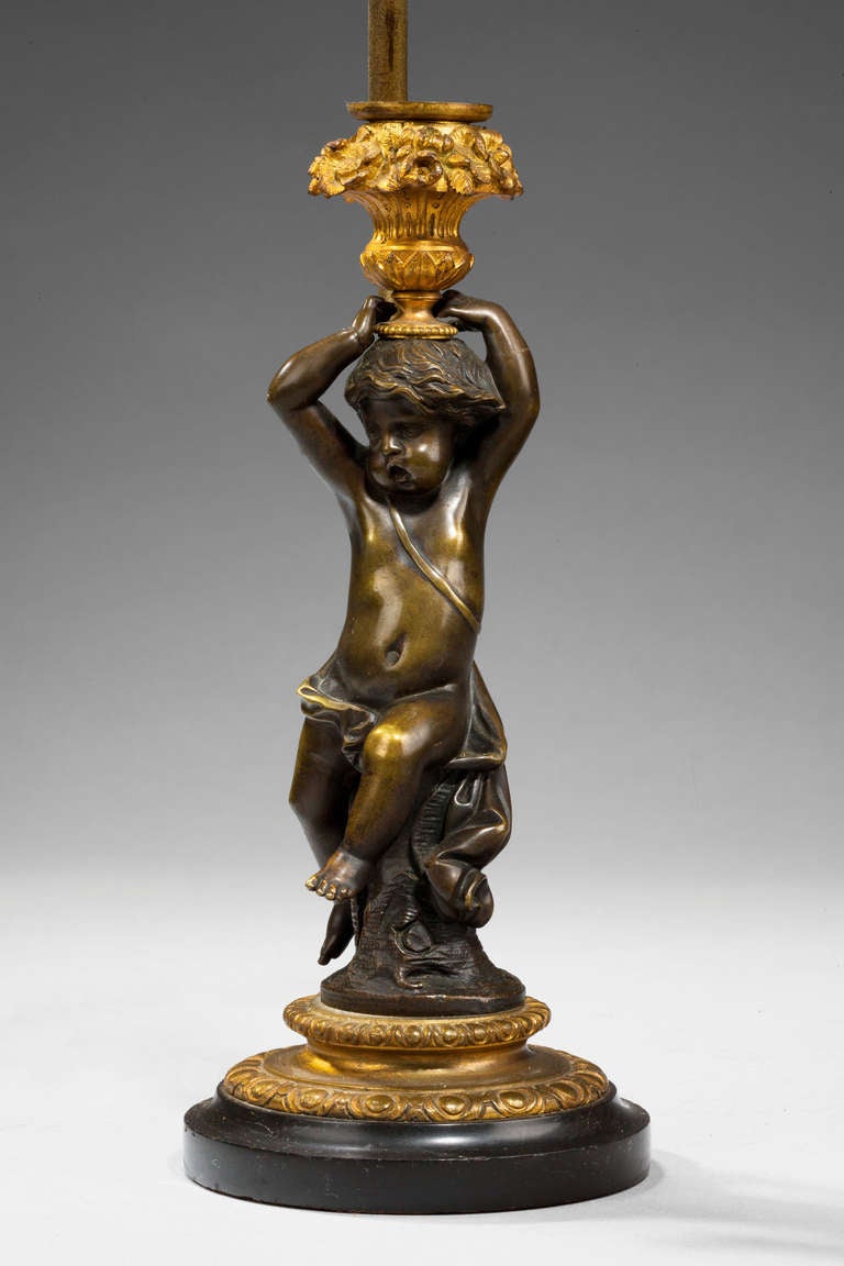 French bronze and gilt bronze putto in the form of a lamp, original surfaces.

Shades are not included in the price of our lamps. We do have a competitively priced range of shades for all of our lamps. Please ask for details with your inquiry or