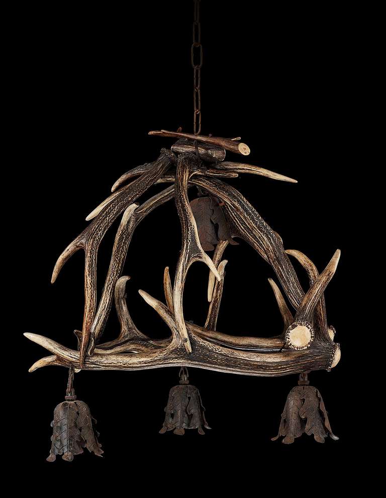 A good, early 20th century stag's horn chandelier, the four lights contained within cast bronze outer frames.

Provenance:
Horn furniture is a name given to furniture made from the horns and antlers of animals such as cattle (usually long horned