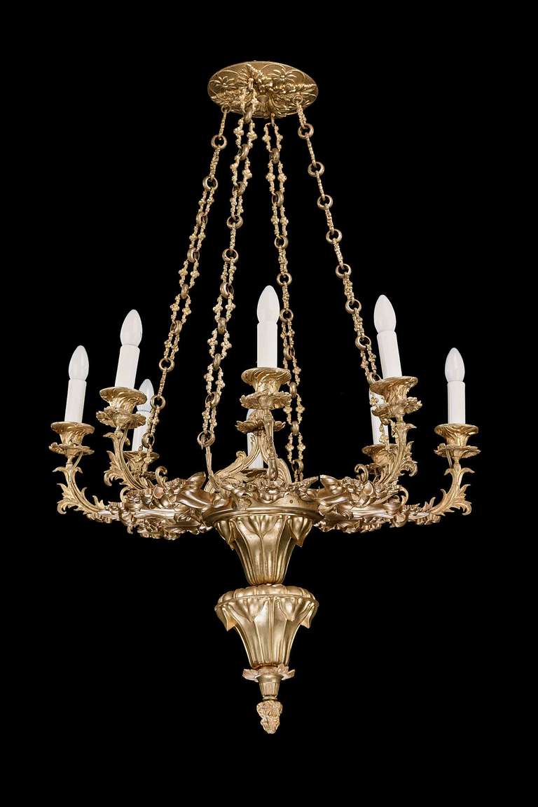 A good and elaborate cast gilt bronze, French chandelier, eight arms with chiseled and shaped Rococo decoration, retaining very fine and elaborate original cast set of chains, the top with a dish rose chiseled with foliage and flowers.


