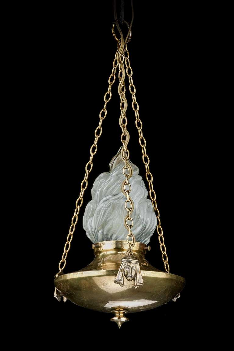 A small, Regency style brass and bronze chandelier, the dish circular section with applied cast heads. The single opaque glass centre with one light.