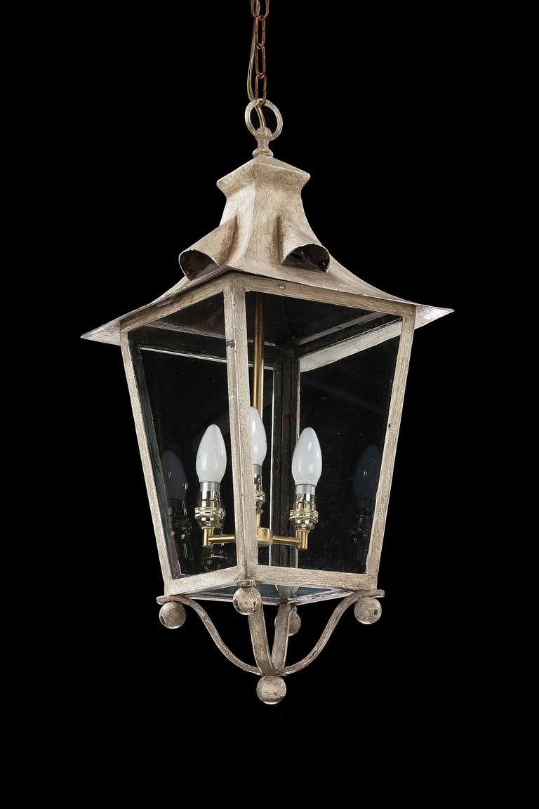 Painted and patinated off-white four-pane lantern, the inner support with three lights, the paintwork original and oxidised.

RR.