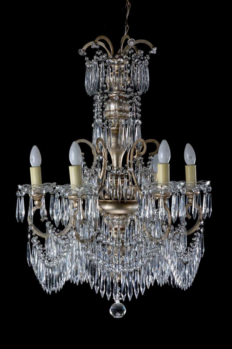 An attractive and unusual cut-glass and gilt bronze six-arm chandelier, the base section with tiered swags and drops, the centre section shaped and with fine matching pendant drops.