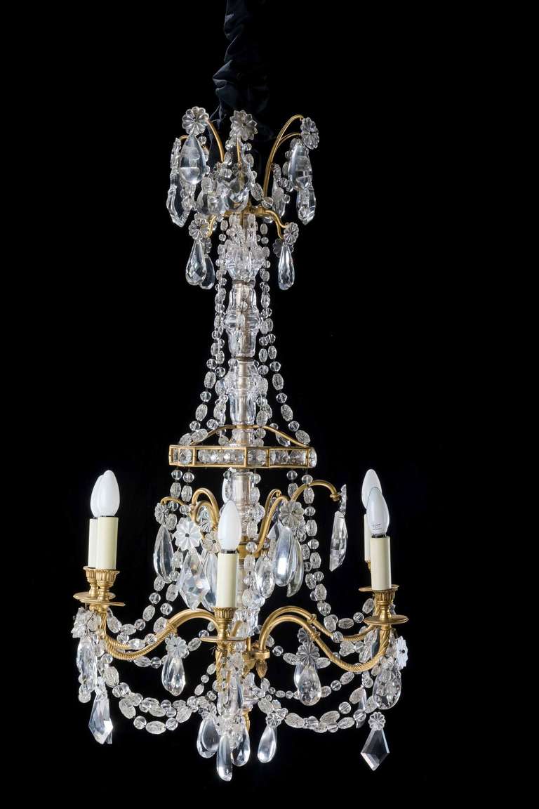A French gilt bronze and cut-glass six-arm chandelier, the shaped arms with writhen sections, large oval and shaped pendant drops joined with complex beading.


