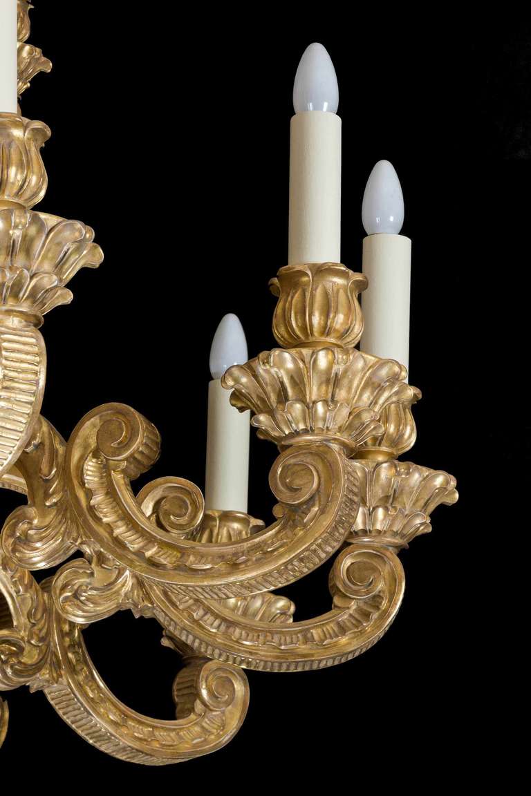 An outstanding giltwood late 19th century eighteen-arm chandelier of classical Rococo and Baroque design, the whole body and arms finely carved with highlighted and matte gold leaf decoration.


