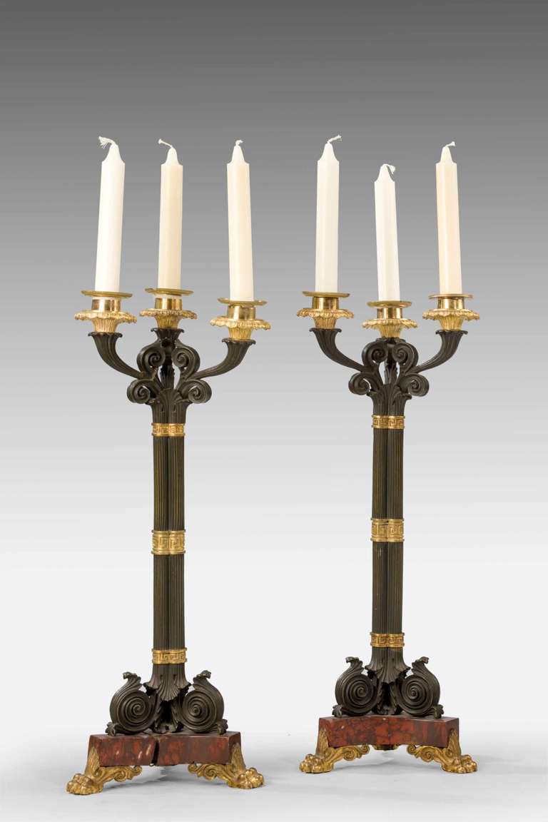 A good pair of 19th century bronze and gilt bronze tri form candelabra on rouge marble plinths, fine chiseled reeding, Grecian key borders and chiseled feet. Original surfaces.