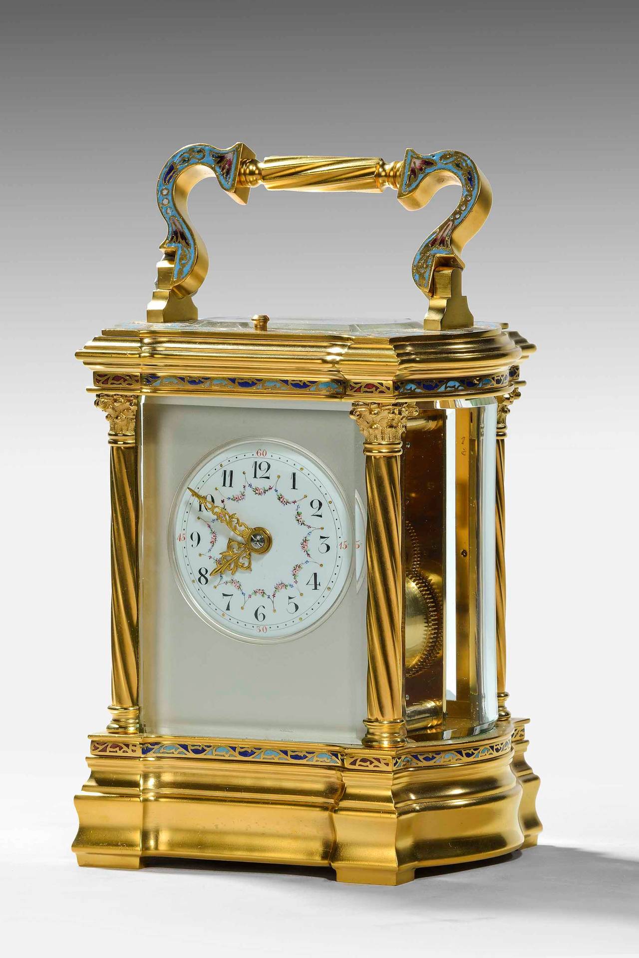 An exceptionally fine Champlevé repeating carriage clock in a gilt bronze case, with enameled numerals and face. Bow ends, cast original handle and a repeat mechanism. Of the very finest quality. Completely restored and in perfect working condition.