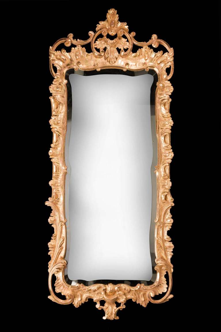 A finely carved mid-18th century Rococo giltwood mirror, the frame with continuously flowing foliage and scrolls surmounted with a very well carved pediment.

RR.