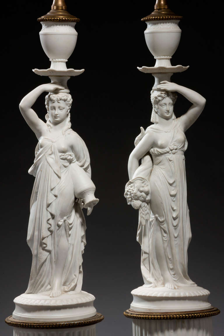 Pair of white biscuit porcelain Lamps of neoclassical design on original bases with gilt decoration.

RR.