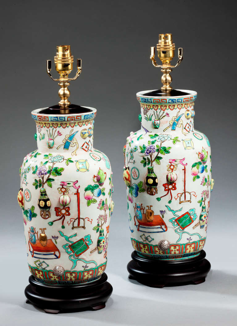 Pair of porcelain Lamps of Canton design, with raised 'one hundred antiques' enamels. Modern.

Canton porcelains are Chinese ceramic wares made for export in the 18th to the 20th centuries. The wares were made, glazed and fired at Jingdezhen but