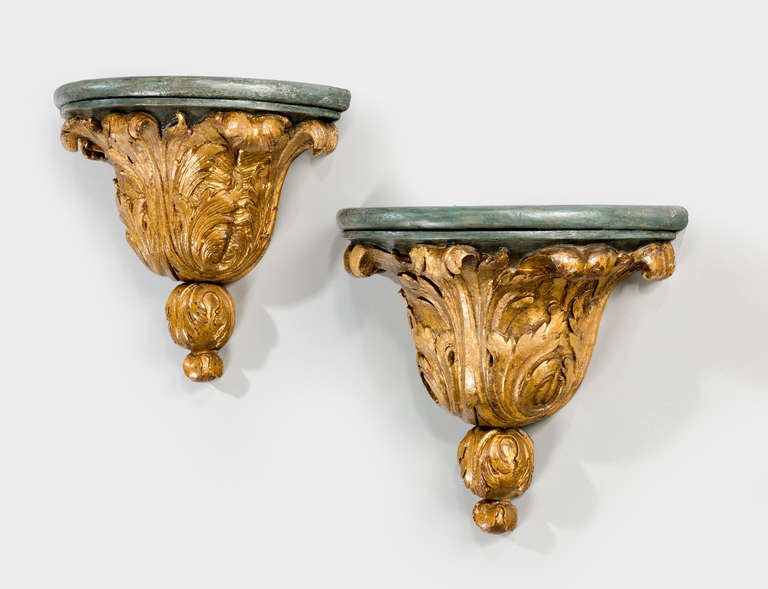 A good pair of mid-18th century gilded and parcel gilded brackets, the feathered bases somewhat worn and the gilding tired and unusual.

