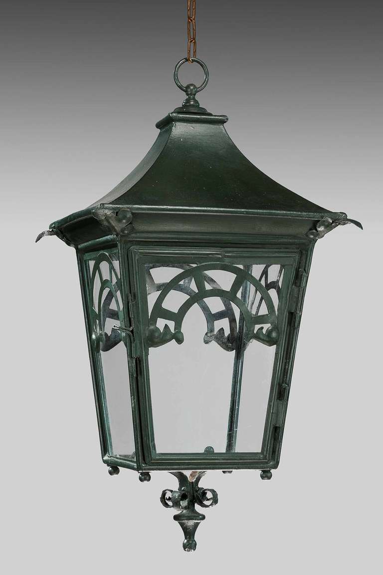 Pair of early 20th century patinated bronze four glass lanterns, the finish of dark green, the lantern with flared a top section and scroll to the base.

