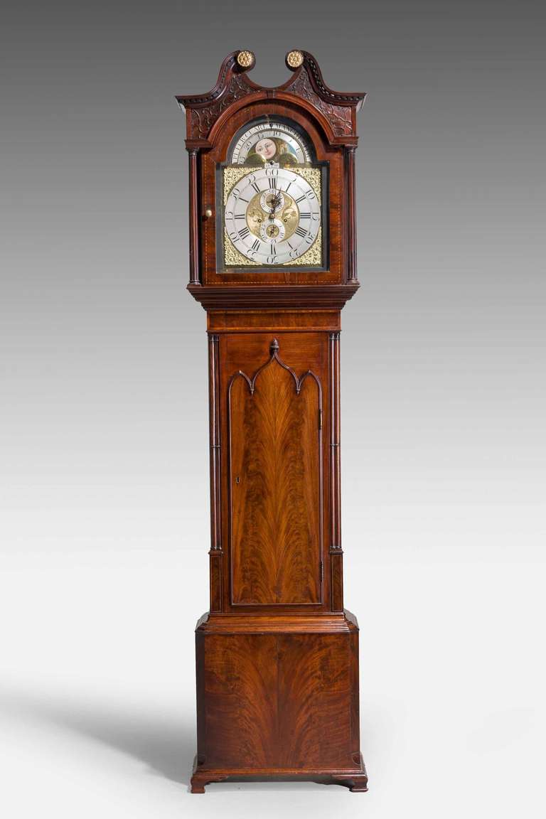 George III period longcase clock by Peter Clare of Manchester with eight day movement, moon dial aperture and two subsequent dials, finely figured case with original gilt bronze spandrels, face partially silvered. Well figured triple arch Gothic