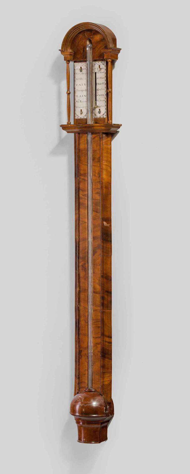 A very good early 18th century walnut barometer, walnut veneers applied to the oak carcase with an open cistern cover, hood pillars and curved pediment.

For a very similar example see Nicholas Goodison's book on English barometers page 201 plate