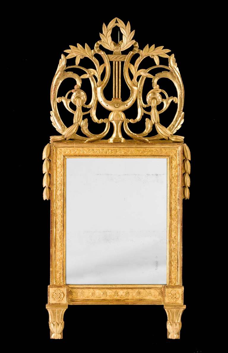 A late 18th-century Italian carved Mirror of rectangular form, the classic shape with a carved wreath and harp to the top between well-shaped leaves.
