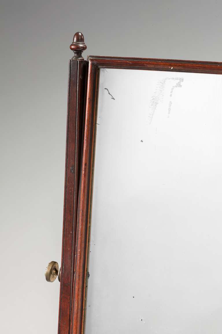 Mid-18th century mahogany dressing mirror, with finely turned uprights, framing an original plate, swept base with three drawers on bracket feet.

RR.