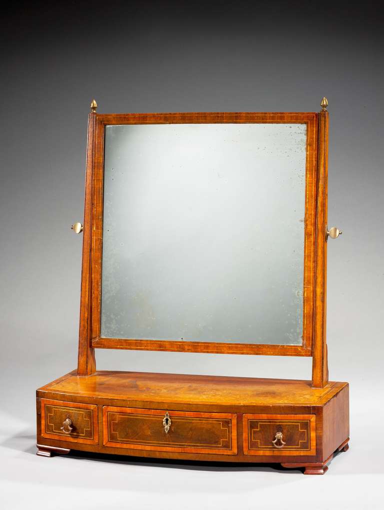 George III period bow fronted mahogany dressing mirror with very well figured timbers, boxwood, ebony and satinwood inlay standing ogee bracket feet.

