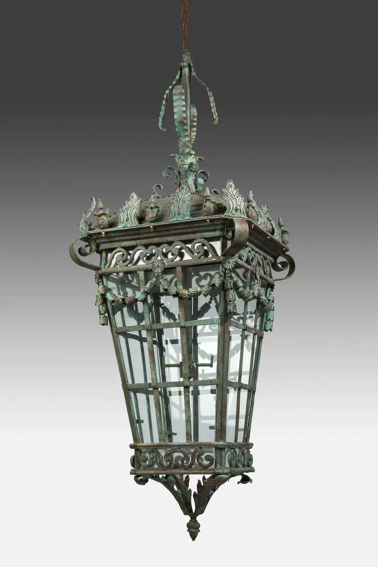 A massive patinated bronze lantern, the upper framework with scrolls and swags and flared leaf decoration.