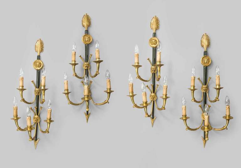 A most unusual set of four 19th century gilt bronze and gunmetal wall lights, the five arms emanating from well chiseled lion masks, the supports with anthemion cast decoration, the base terminating in an arrowhead.
