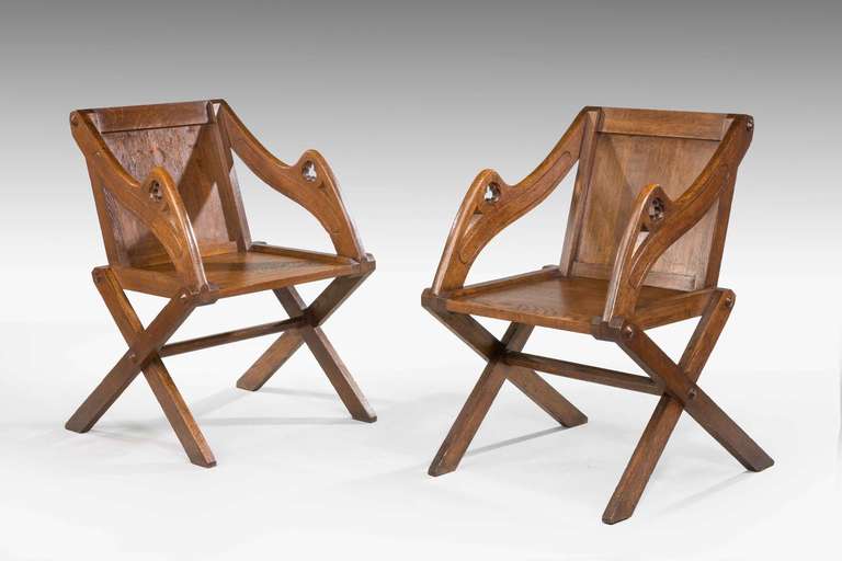 Pair of late 19th century oak Glastonbury armchairs, good color and patination.

Glastonbury chair is a 19th century term for an earlier wooden chair, usually of oak, possibly based on a chair made for Richard Whiting, the last Abbot of