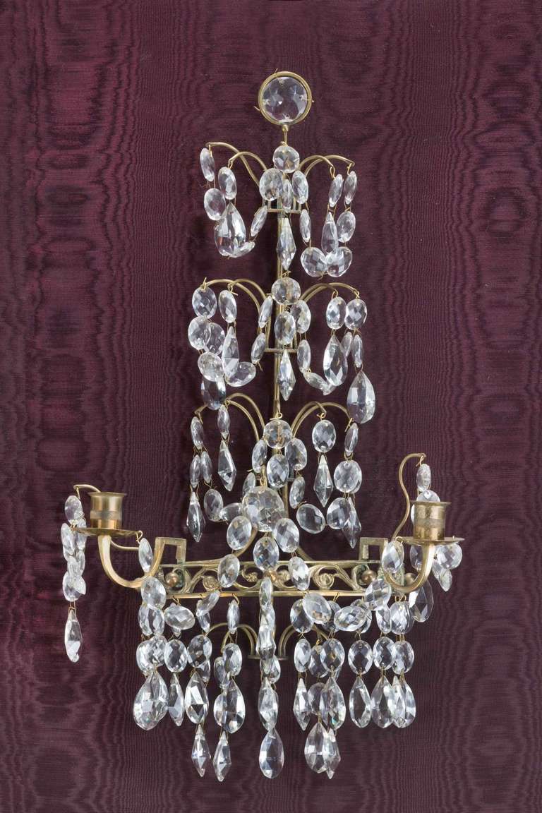 An attractive suite of Four 19th Century Cut glass and gilt bronze Wall Lights, each holding two candle arms with graduated pendent drops.