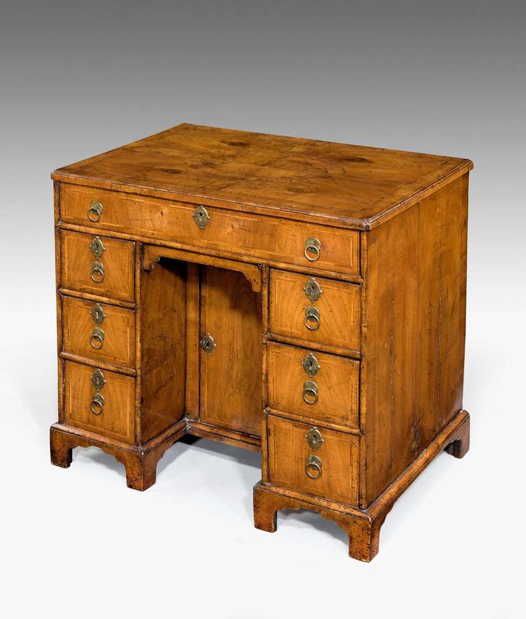 A good George II period walnut Knee hole Desk the quartered top with an unusual cross banded oval inlaid centre, the drawer fronts with fine herringbone detail. The stile fronts with cushion molding.

RR
