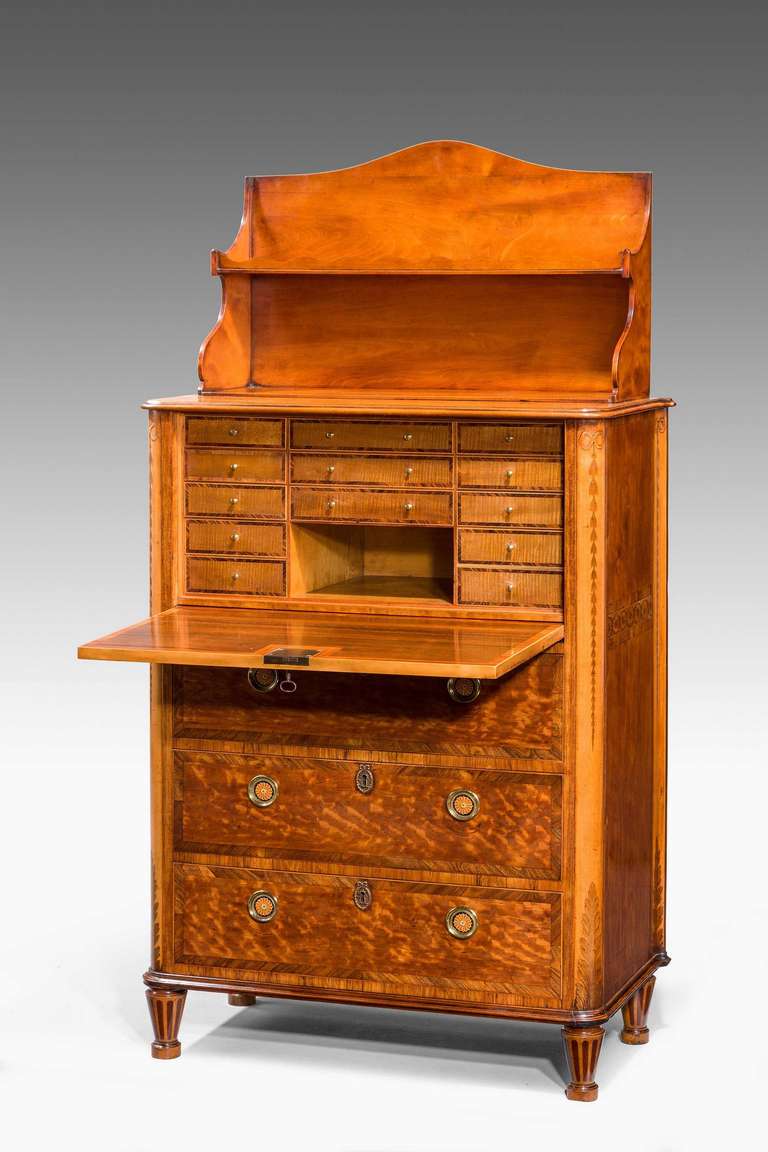 A quite exceptional and rare satinwood secrétaire abattant with superbly figured timbers, the fall quarter with oval borders of marquetry inlays, the rounded supports inlaid with slender falling harebells. Three drawers beneath the fall front, the