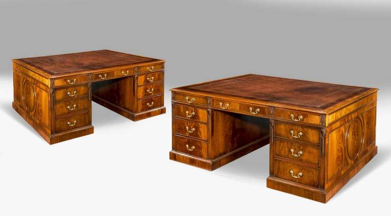 A highly unusual pair of mahogany partner's desks with beautifully figured timbers. Identical on both sides with nine drawers retaining original inset leather tops, early 20th century.