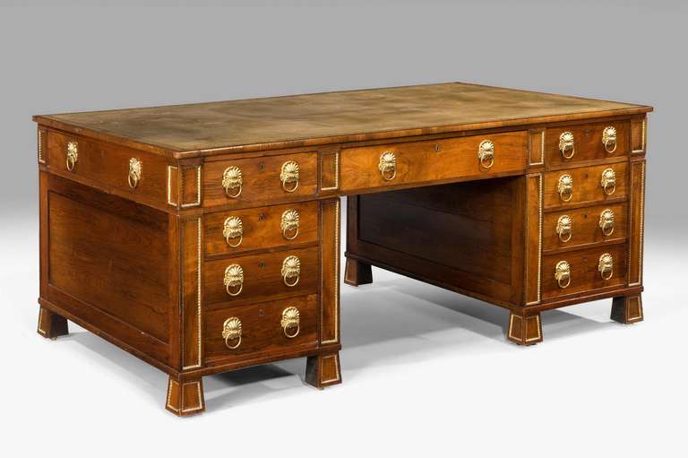 A fine Regency period rosewood partner’s desk of beautiful honey coloured timbers and with original gilt bronze mounts and handles, the reverse with nine drawers, inset leather writing surface and unusual square section feet.