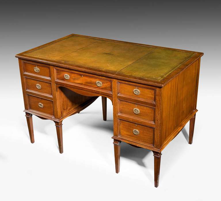 A pretty late 19th century mahogany writing desk, the drawer fronts attractively recessed and retaining original gilt bronze handles, the top cross banded, inset leather top in attractive slightly faded olive color, delicately formed tapering