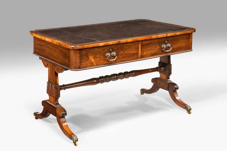 A fine Regency period library table with finely carved end supports joined by a turned high stretcher. Original gilt bronze hardware, the whole of the very best quality and in the very best state.


