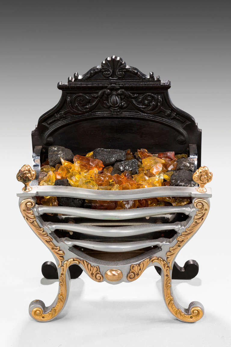 A mid-20th Century steel and brass fire grate in French taste, strong waisted faced, very elaborate cast iron upper-section.
