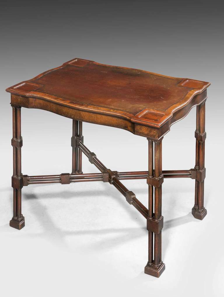 Unusual late 19th century small serpentine mahogany writing table, retaining original inset leather top, supported on cluster columns with matching cross stretcher.

RR.