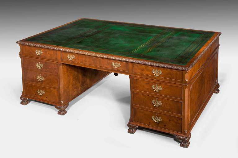 A very well figured late 19th Century mahogany Partners Desk, nine drawers to the face side, three drawers and two cupboards to the reverse, canted corners to the pedestals, Bramah locks, drawers relined, top finely carved border with replaced full