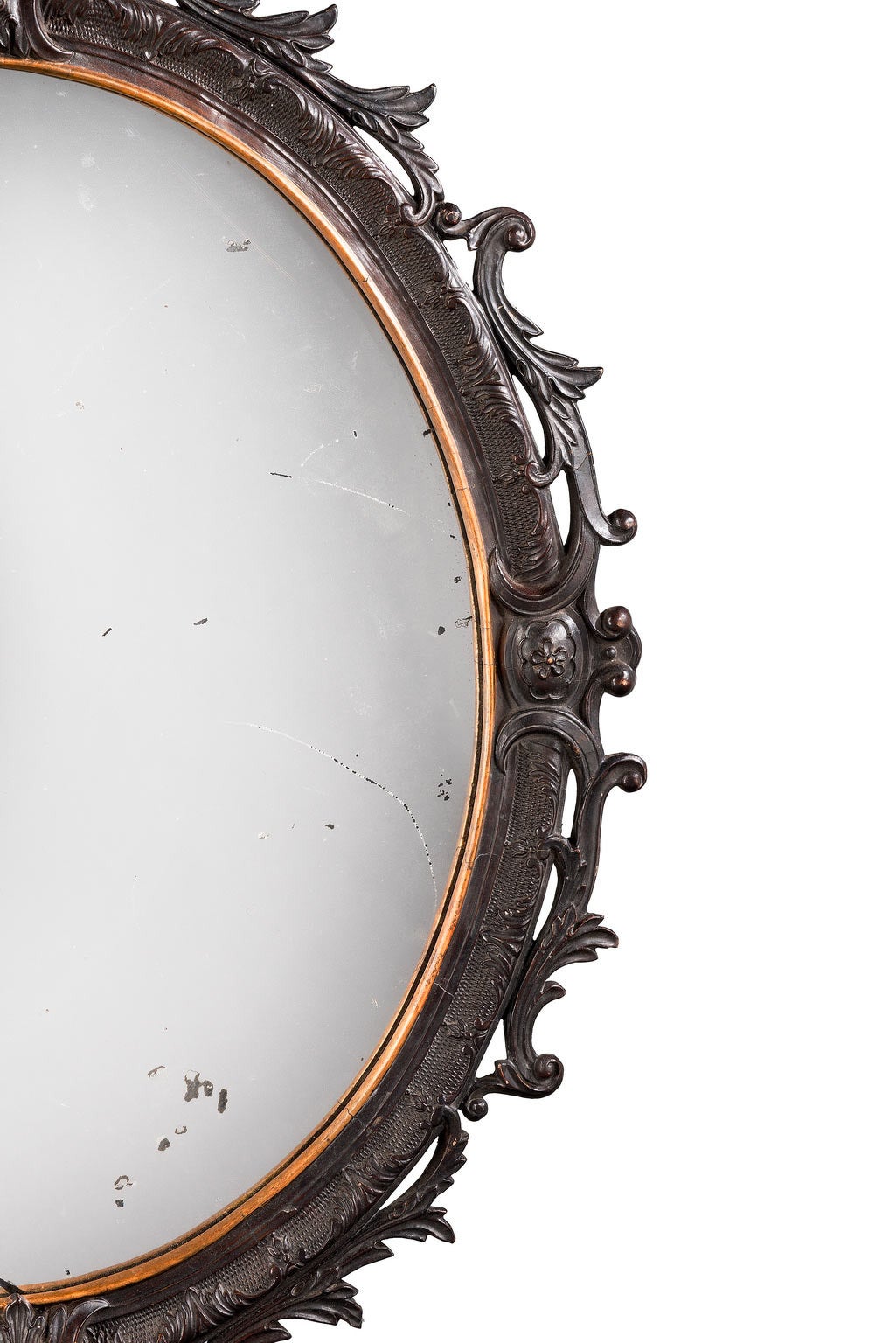 A very finely carved oval late 18th century mahogany mirror. Elaborate scroll work to the outer edge with a punched inner section. The glass surround gilded period plate.