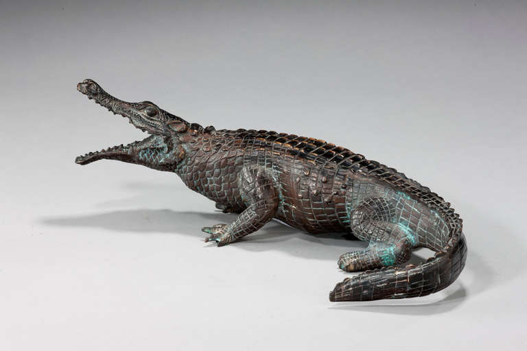 A bronze figure of an alligator with dark brown pattern.