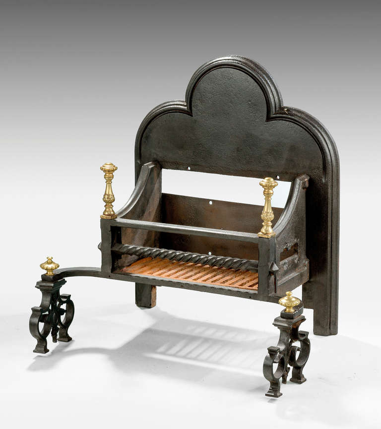 A Regency period cast iron and brass dog grate on unusual scroll supports, arched top.

RR.