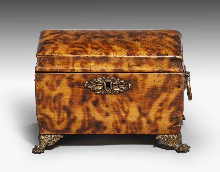 Regency period faux tortoise shell tea caddy, the interior with two compartments, retaining turned ivory knobs, original gilt bronze feet and escutcheons.

The word tea caddy is believed to be derived from catty, the Chinese pound, equal to about