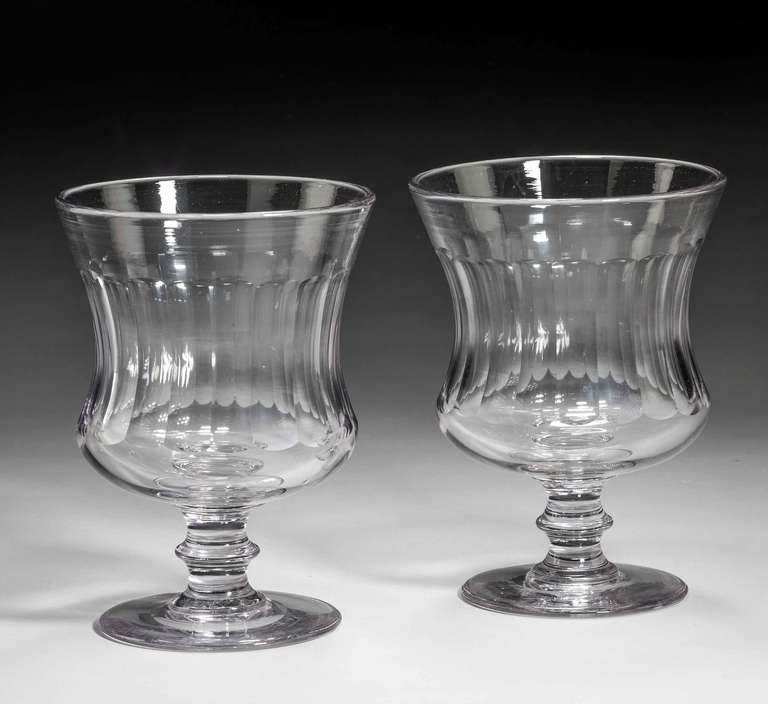 A good pair of late George III period glass goblet vases, the glass of dense fine color, faceted cut bowls over knopped cut stems.

RR.
